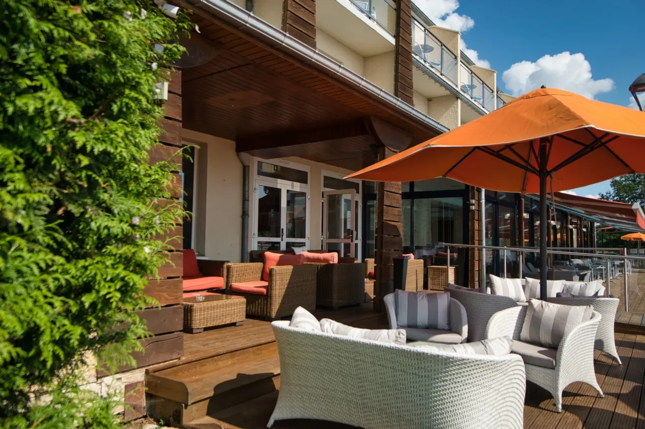 Terrasse avec mobilier en osier et parasols orange