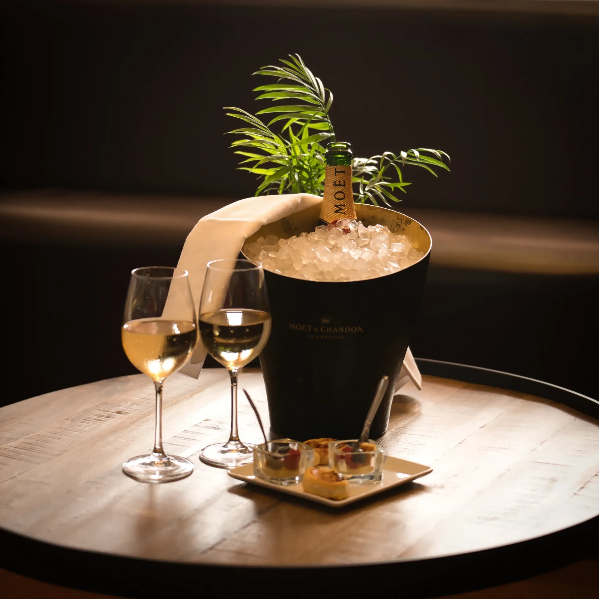 Deux verres de champagne sur table avec amuse-bouches.