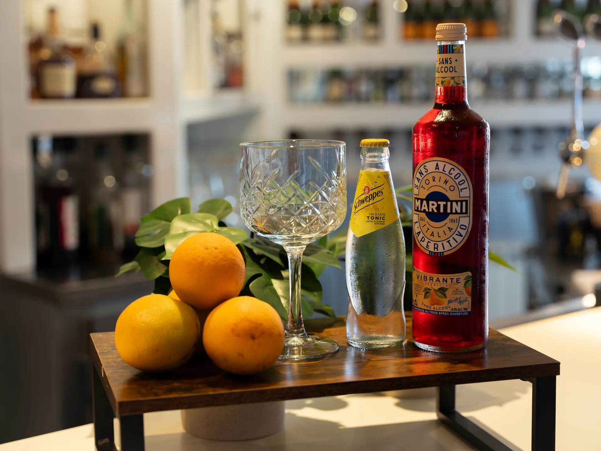 Bouteille Martini sans alcool et agrumes sur table.