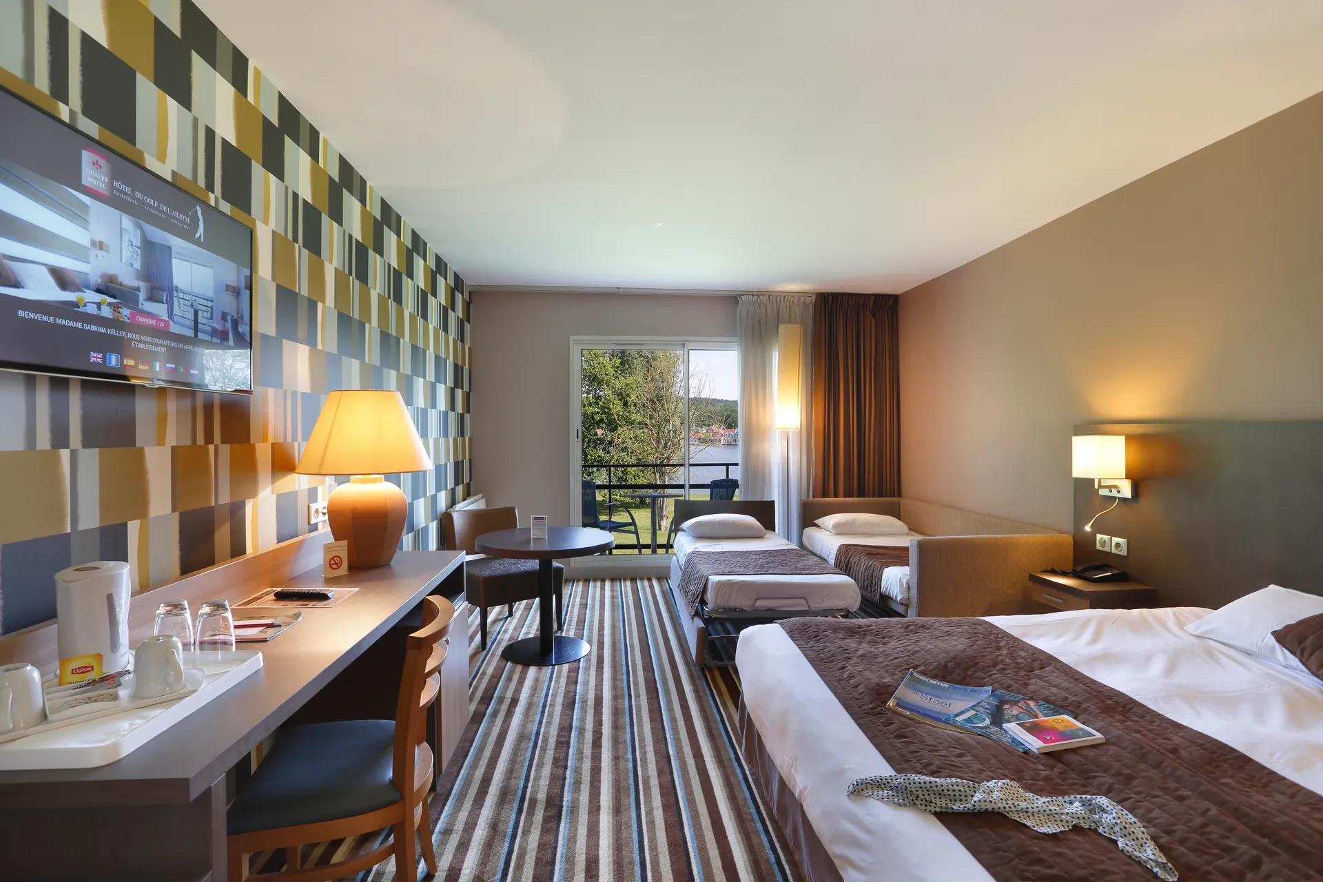 Chambre d'hôtel moderne avec trois lits.