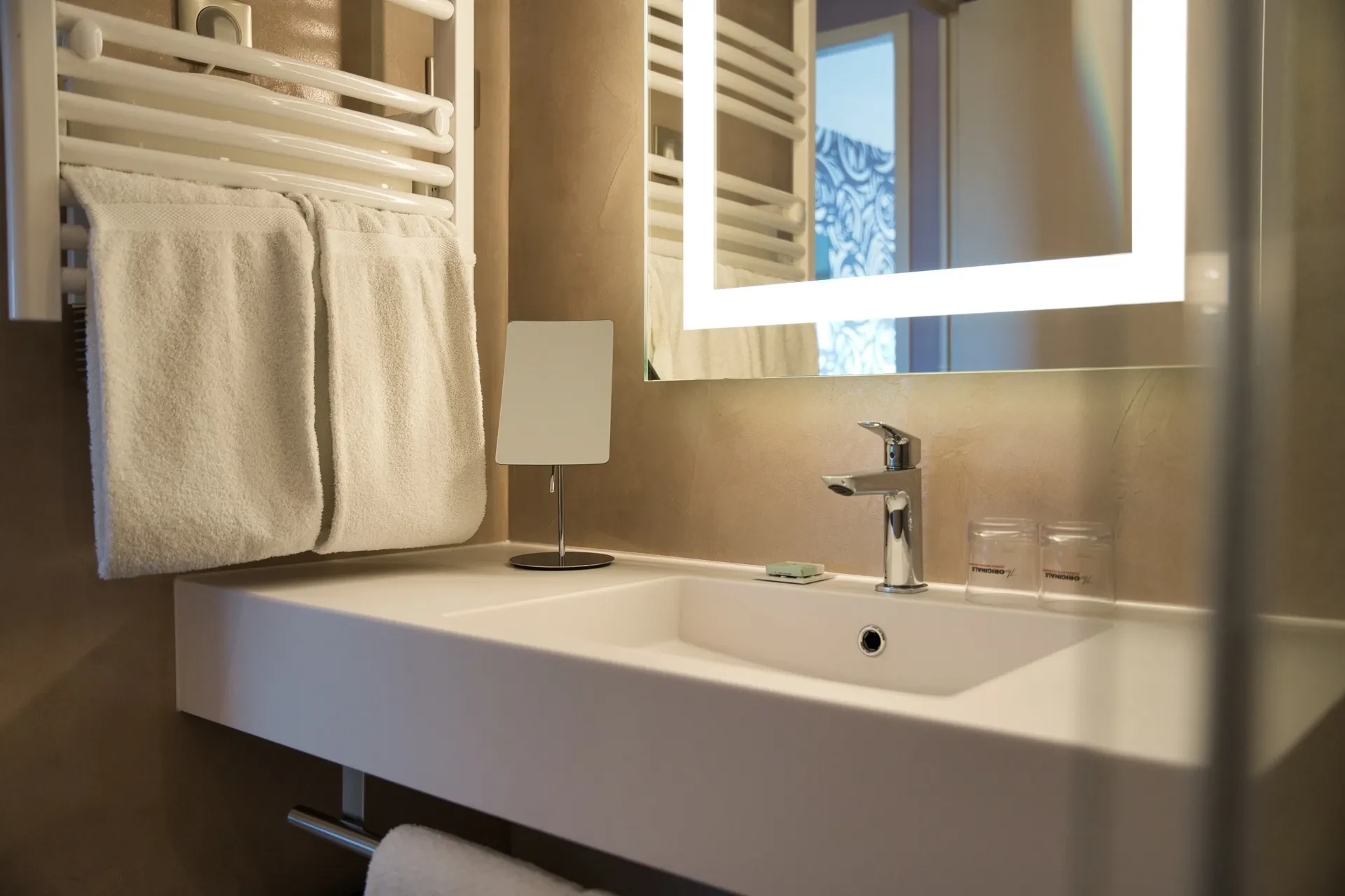 Salle de bain moderne avec serviettes blanches.