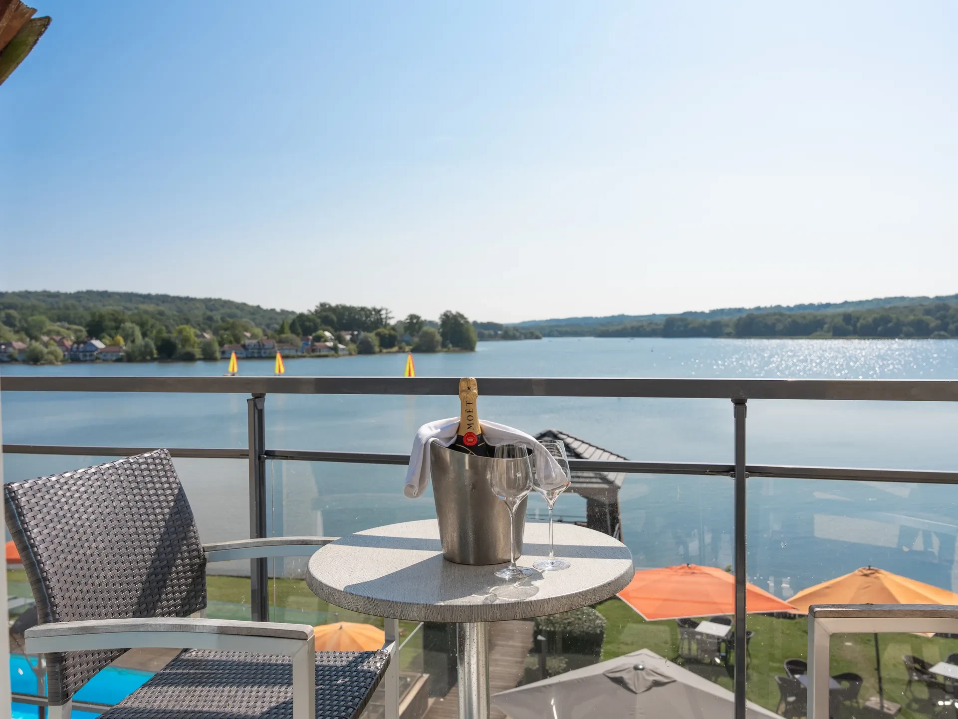 Terrasse avec vue sur lac et champagne.