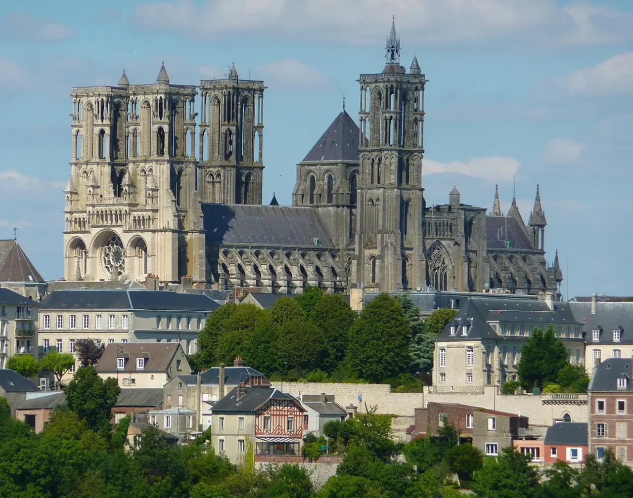 Cathédrale gothique avec tours imposantes en ville.