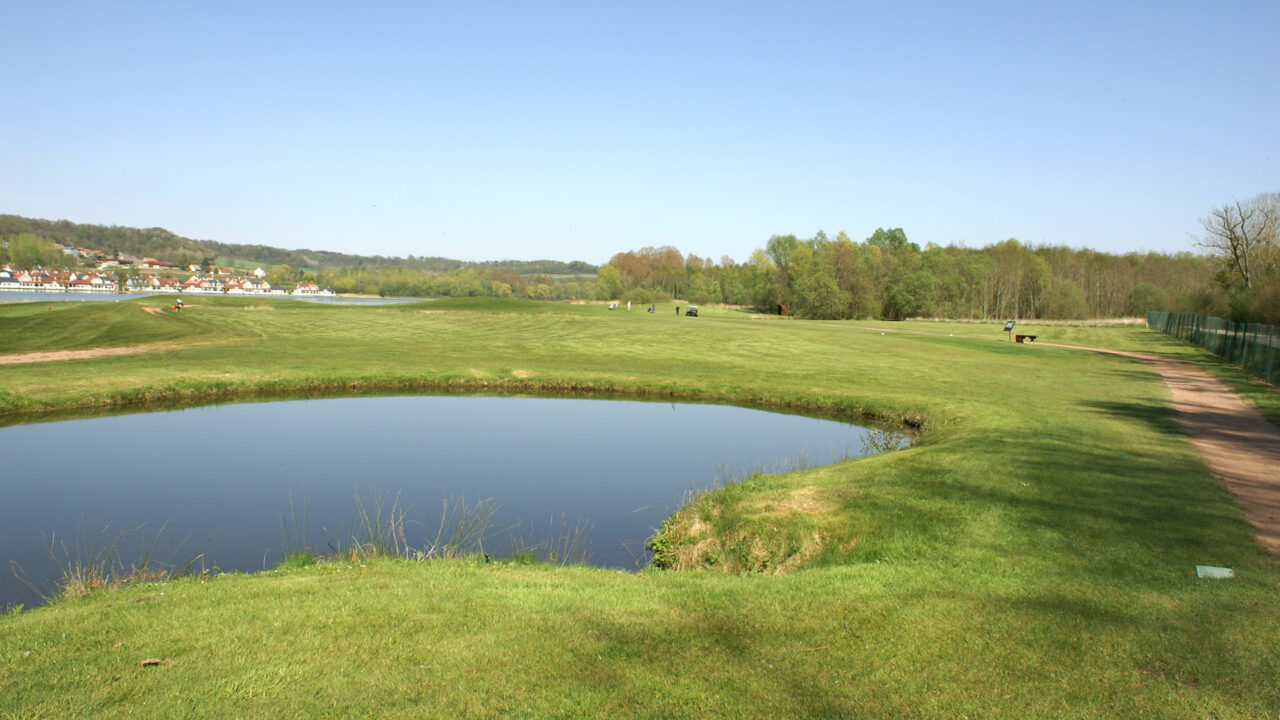 Plan d'eau et fairways ensoleillés au Golf près de Reims