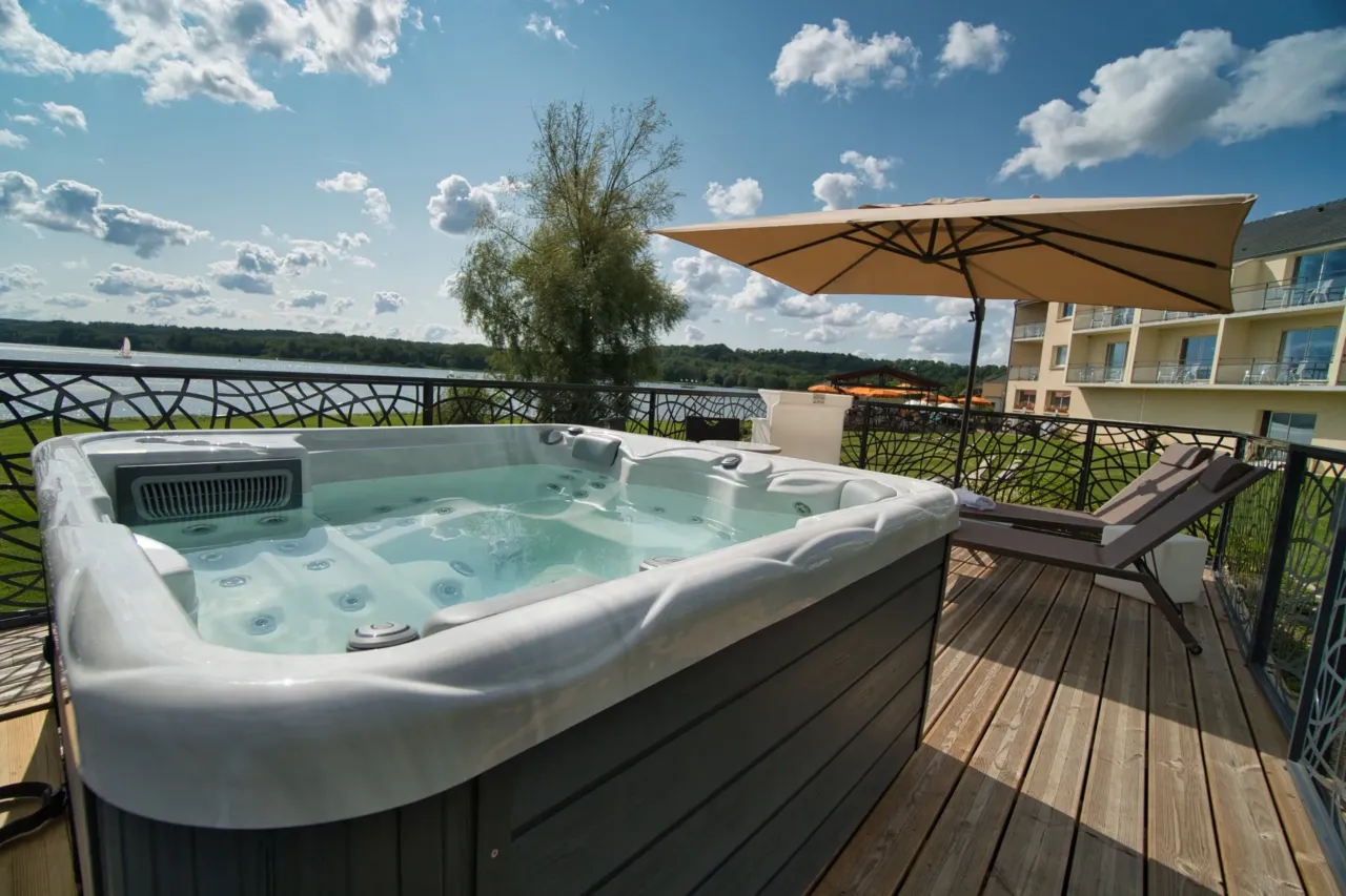 Jacuzzi extérieur avec vue sur la rivière.