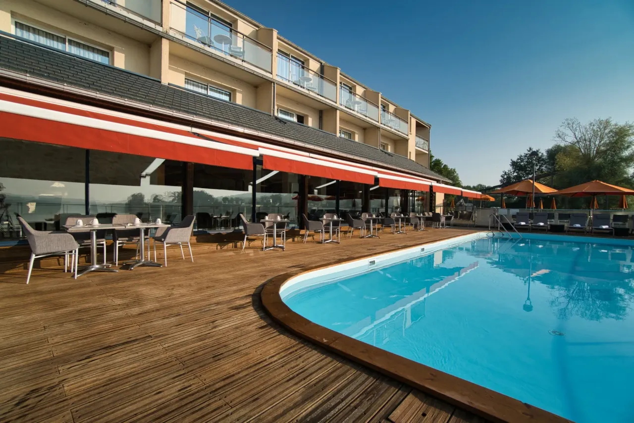 Terrasse de restaurant avec piscine et parasols.