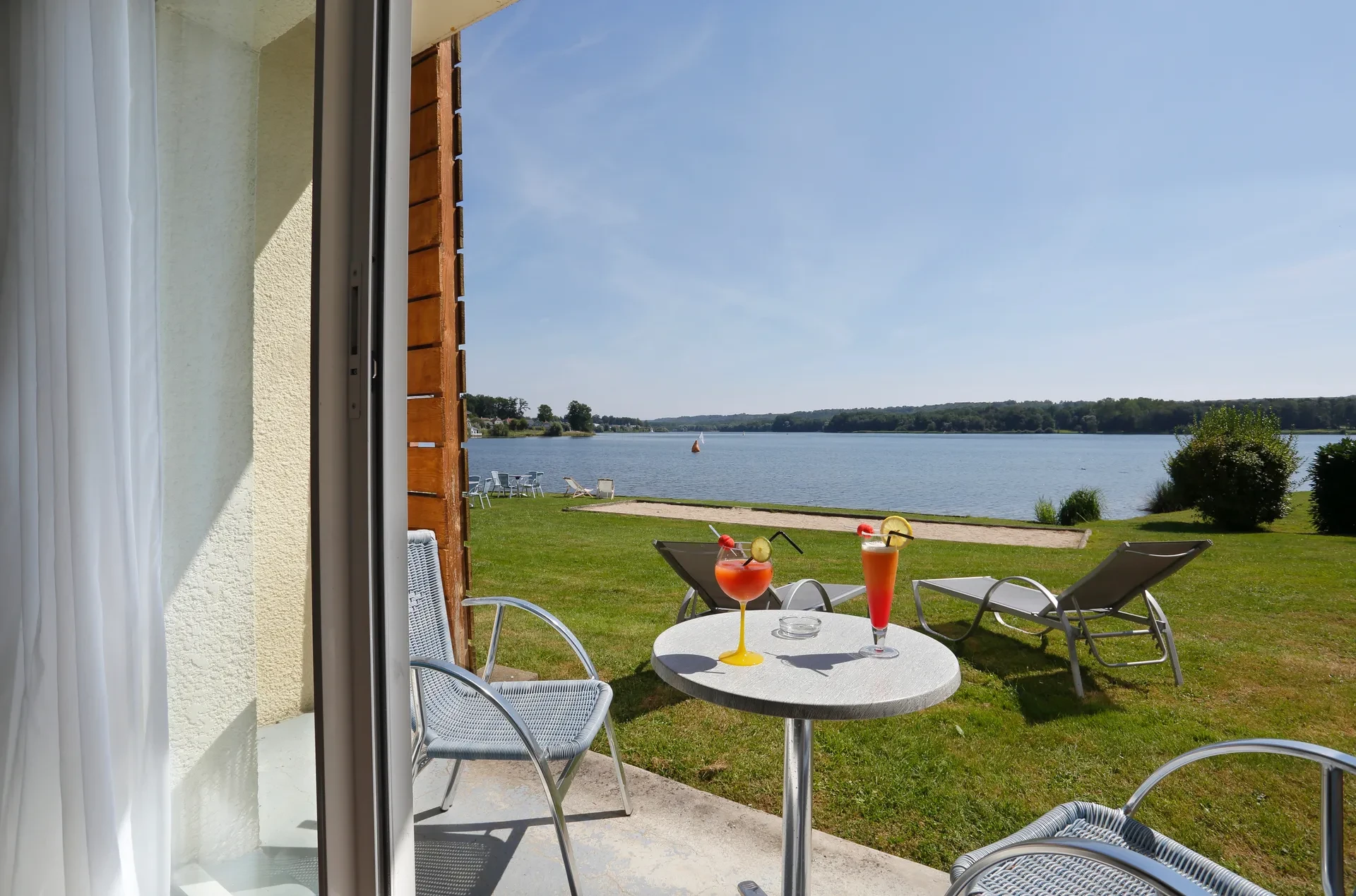 Terrasse en bord de lac avec cocktails colorés.