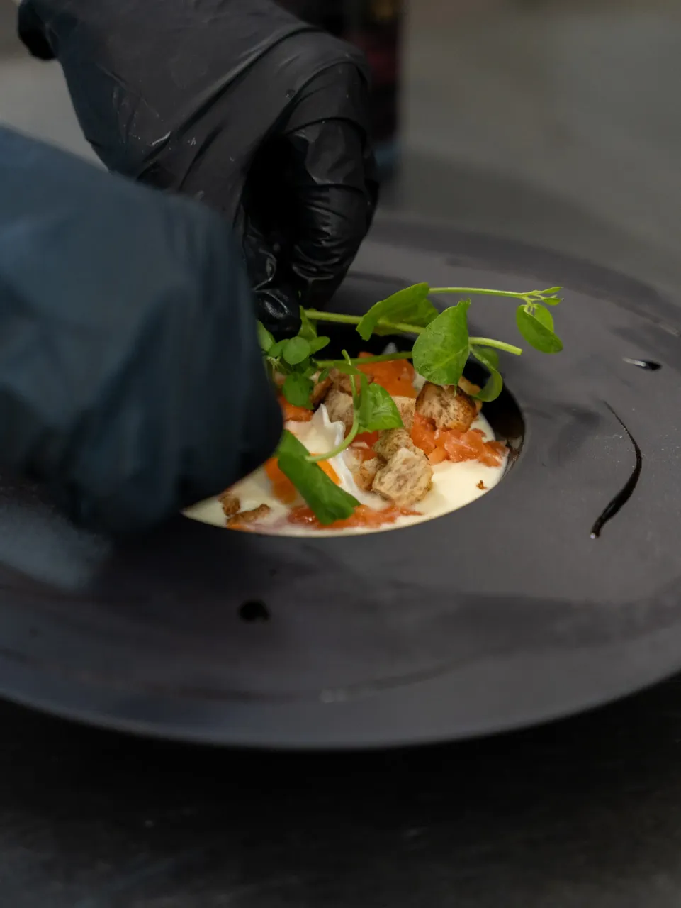 Chef préparant un plat gastronomique délicatement.