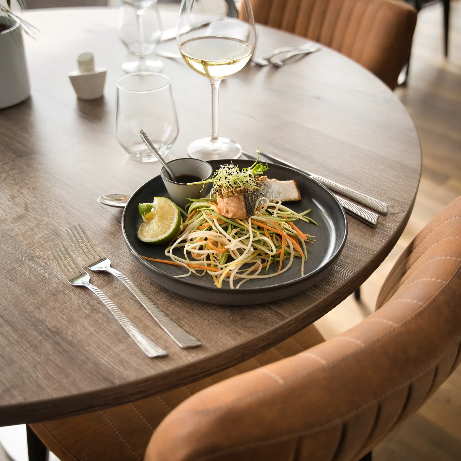 Plat gastronomique dressé sur une table en bois dans un restaurant moderne.