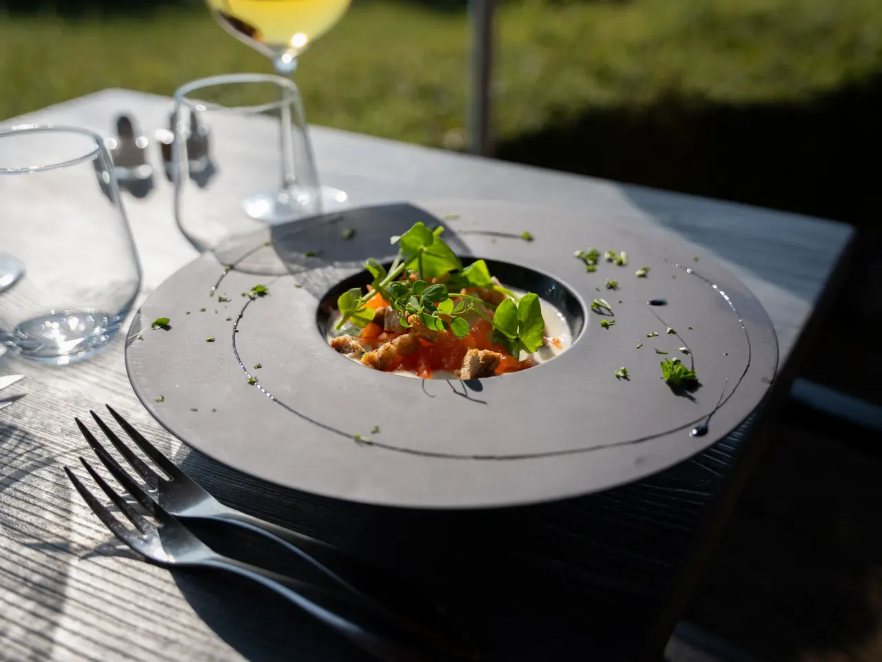 Assiette gastronomique avec décoration verte.