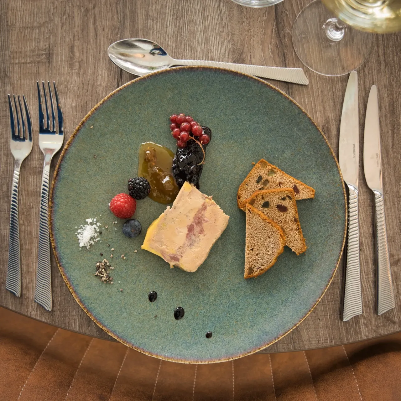 Assiette de foie gras avec fruits et pain.