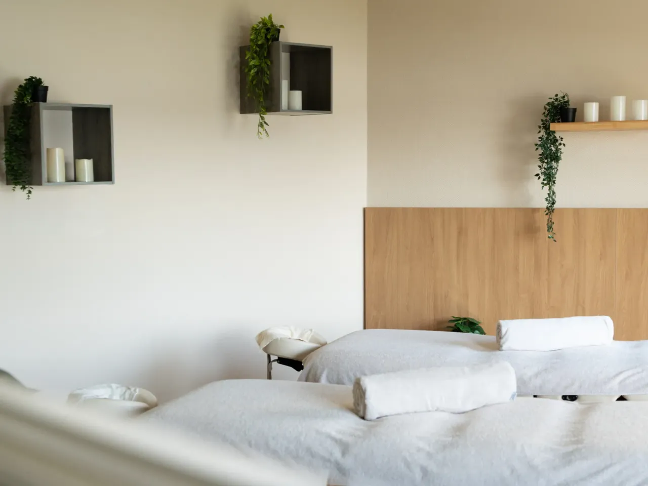 Salle de massage avec lits et décoration végétale.