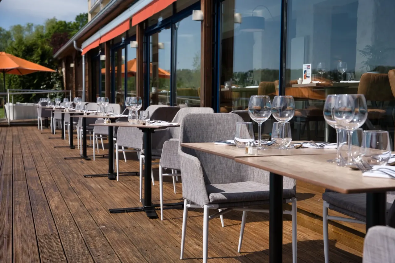 Terrasse de restaurant avec tables dressées.