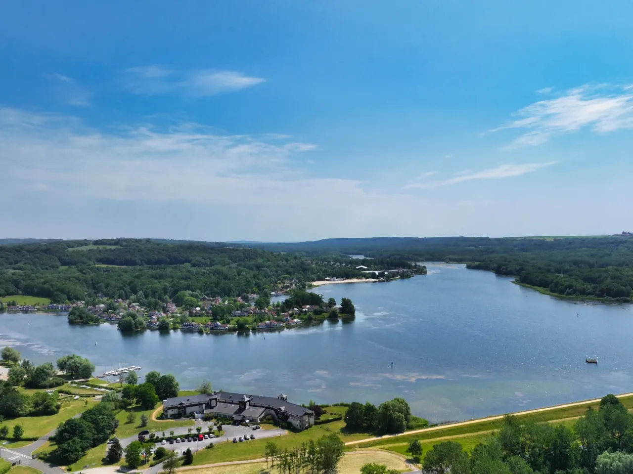 Vue aérienne d'un lac entouré de forêts.