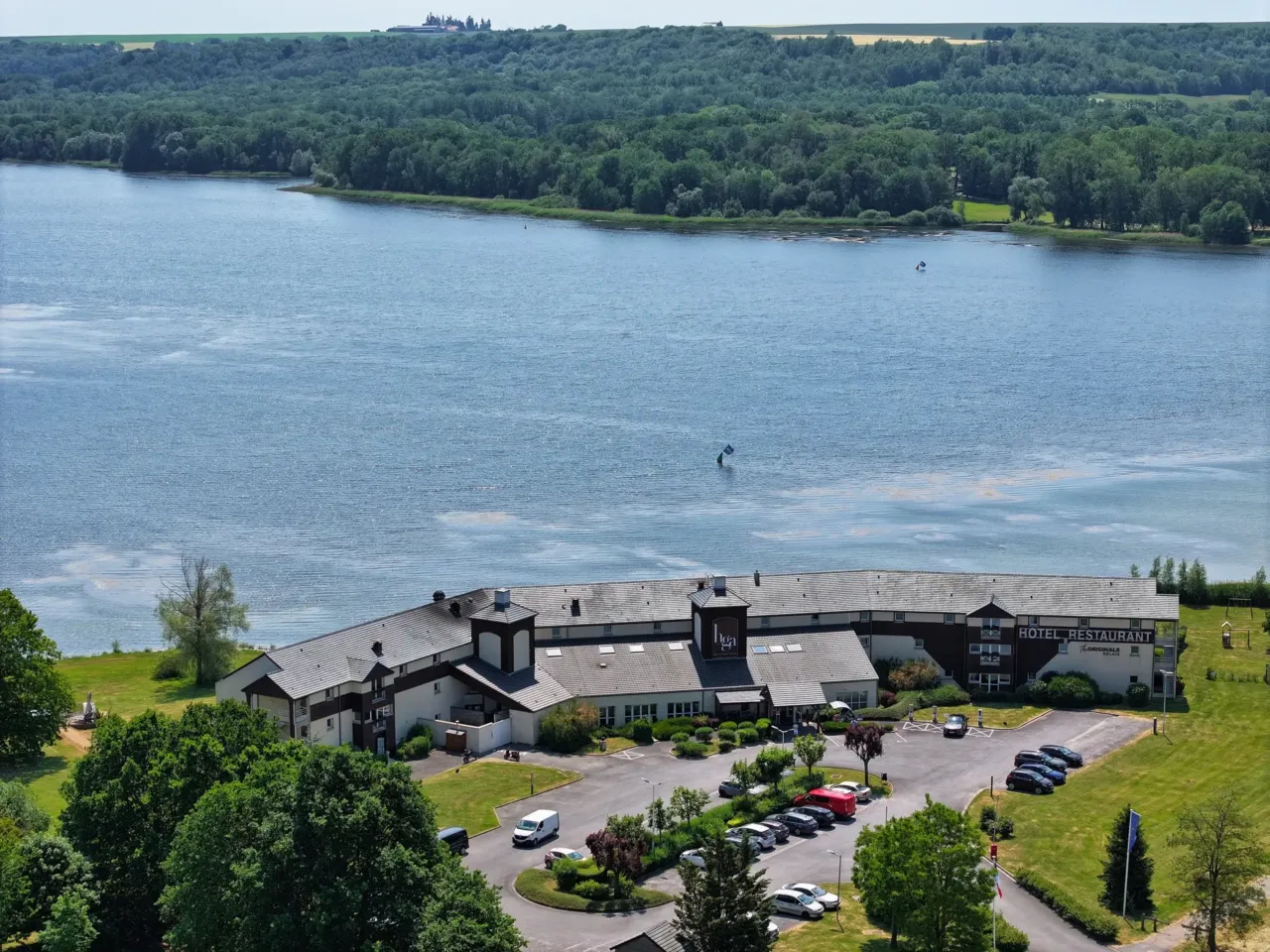 Hôtel-restaurant au bord du lac entouré de forêts.